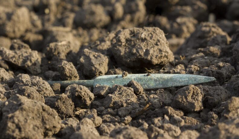 Vârf de săgeată din metal, în pământ, pentru a ilustra cum experții au găsit o armă antică creată din meteorit