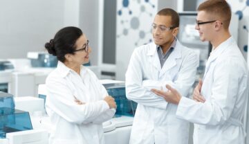 3 cercetători, ămbrăcați în halate albe, într-un laborator, ca cei în cazul cărora experții au observat formarea unui nou accent