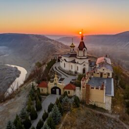 Mânăstire din Orheiul Vechi, Moldova, la apus, pe un vârf de deal. Republica Moldova se numără printre țările europene cu cel mai mic cost al vieții