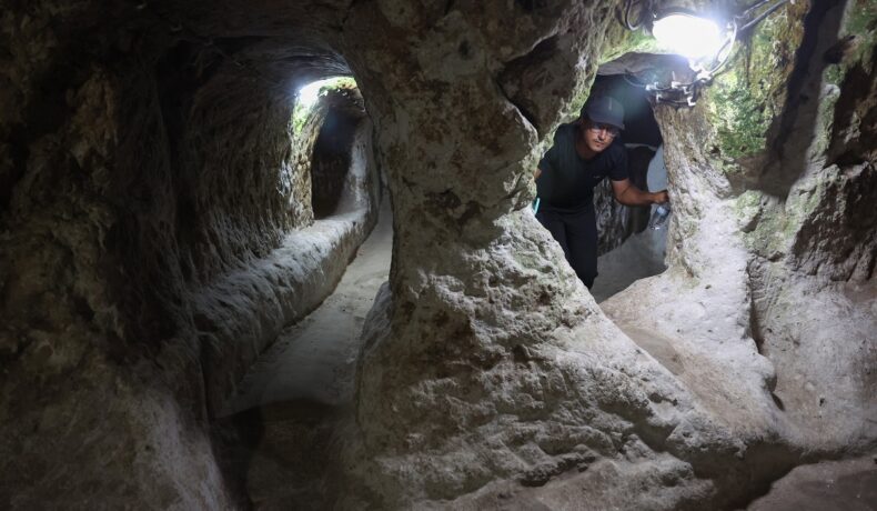 Un turist în Orașul Derinkuyu, aflat în subteran, cu lumină deasupra capului, după ce un bărbat a descoperit un oraș antic sub casă