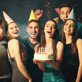 Oameni care sărbătoresc o zi de naștere, cu un tort, pentru a ilustra cât de comună e data ta de naștere