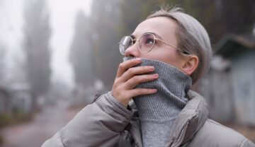 Femeie blondă îmbrăcată în gri care își acoperă gura, pentru a ilustra cât de periculoasă e încălzirea globală