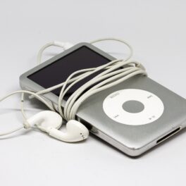 iPod gri cu căști albe, pe fundal alb, unul dintre aceste gadgeturi vechi care costă o avere acum