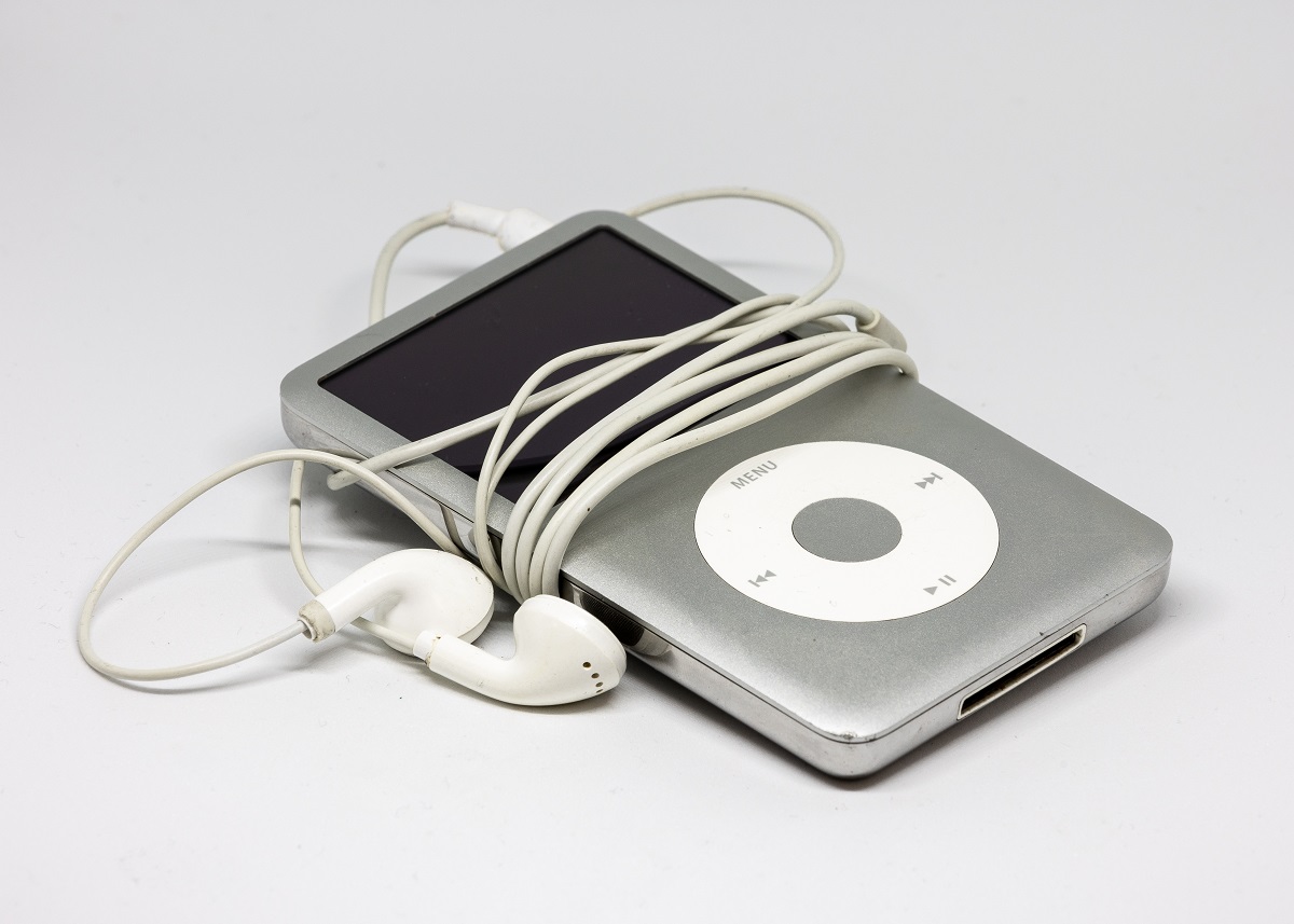 iPod gri cu căști albe, pe fundal alb, unul dintre aceste gadgeturi vechi care costă o avere acum