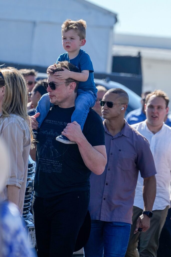 Elon Musk și fiul său X, pe care îl poartă pe umeri, la Grand Prix SUA, octombrie 2023
