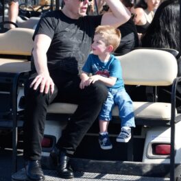 Elon Musk și fiul său X, în spatele unui gold cart, la Grand Prix SUA, octombrie 2023