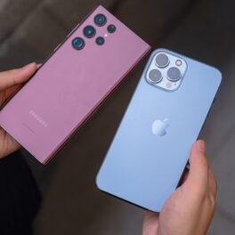 iPhone și Samsung, unele dintre cele mai bune smartphone-uri în 2023, ținute în mână de utiliator, iphone-ul albastru și samsung-ul mov