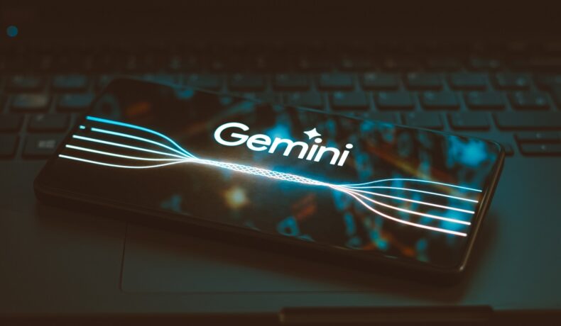 Google a lansat Gemini, care apare pe ecranul unui telefon, pe fundal negru
