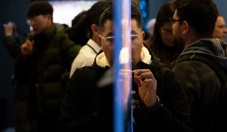 Bărbat care se uită la un ecran transparent, precum cel cu care a uimit Samsung în cadrul CES 2024, 7 ianuarie, Las Vegas