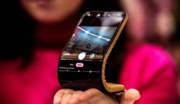 Ecranul Flexibil Motorola prezentat la MWC 2024, Barcelona, ținut în mână d eo femeie îmbrăcată în roz