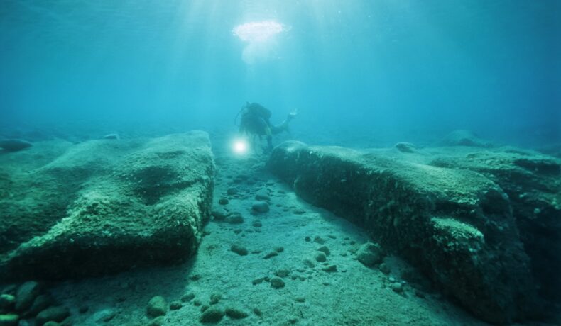 Scafandru care analizează un zid antic ascuns sub ape