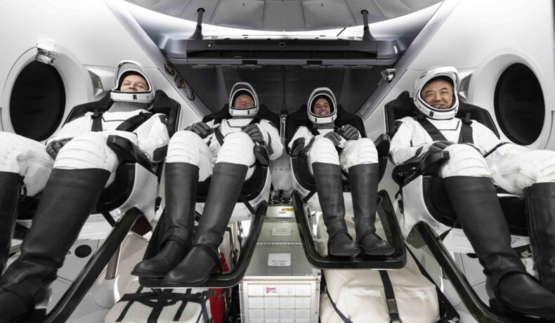 4 astronauți care au revenit pe Pământ pe 12 martie 2024, la bordul unei capsule SpaceX, îmbrăcați în uniforme cu alb și negru