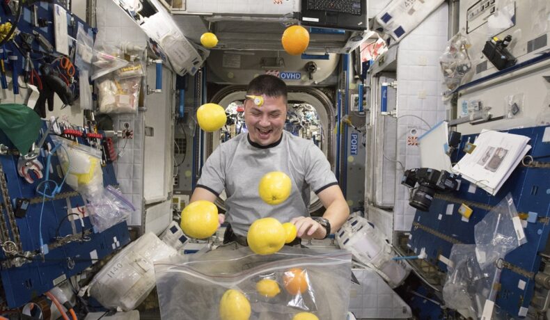 Astronautul Kjell Lindgren cu fructe proaspete la bordul ISS în 2015, diferită de prima mâncare consumată în spațiu