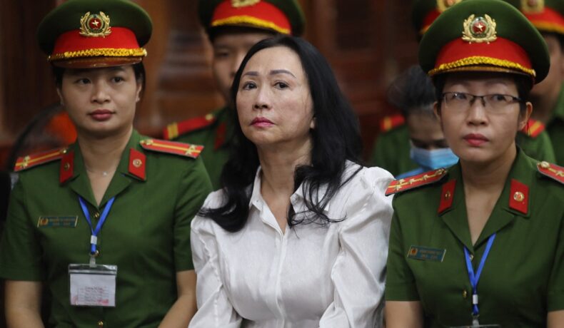 Truong My Lan e miliardara condamnată la moarte îm Vietnam, aprilie 2024, îmbrăcată într-o bluză albă și înconjurată de soldați